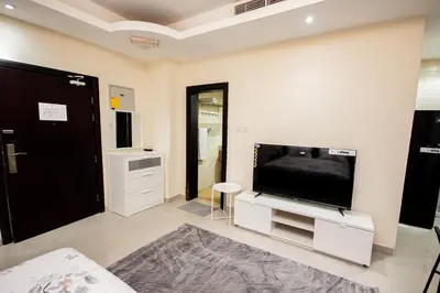 a living room with a large flat screen tv at Newly Furnished Studio at city tower building in Dubai