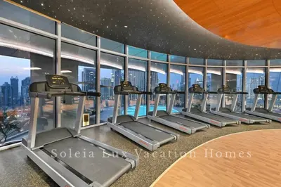 a gym with a row of treadmills in a building at Luxury Condo near Burj khalifa in Dubai