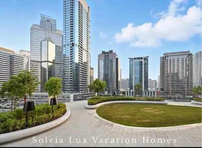 a park in the middle of a city with tall buildings at Luxury Condo near Burj khalifa in Dubai