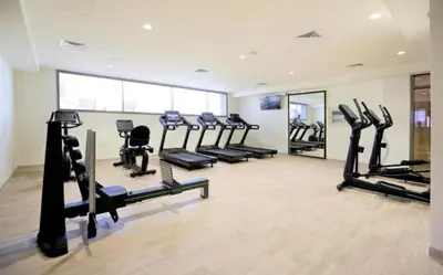 a gym with treadmills and ellipticals in a room at Luxurious cozy studio in Dubai