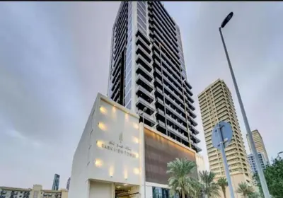 a tall building with lights on it in a city at Luxurious cozy studio in Dubai