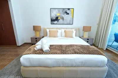 a bedroom with a large white bed with two lamps at Luxe 1BR Hamilton Residency Business Bay with balcony in Dubai