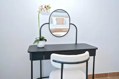 a black desk with a mirror and a white chair at Luxe 1BR Hamilton Residency Business Bay with balcony in Dubai