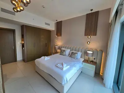 a bedroom with a large white bed and two lamps at Highend Luxury 2BR Direct Burj Khalifa & Fountain Views in Dubai