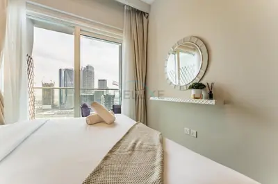 a bedroom with a bed and a large window at Canal View, Easy Downtown Access, Reva Residences, Business Bay by Deluxe Holiday Homes in Dubai