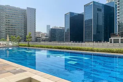 a large blue swimming pool on top of a building at Canal View, Easy Downtown Access, Reva Residences, Business Bay by Deluxe Holiday Homes in Dubai
