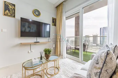 a living room with a tv and a glass table at Canal View, Easy Downtown Access, Reva Residences, Business Bay by Deluxe Holiday Homes in Dubai