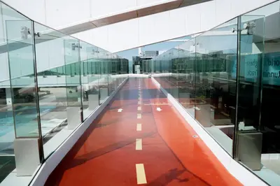 an empty hallway in an airport with glass walls at Luxury 2BR in Al Kifaf with Frame View, Near Trade Center, Metro Access in Dubai