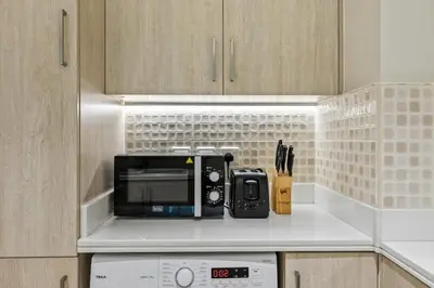 a kitchen with a counter with a microwave and a stove at Infinity Pool & Private Beach 1BR Palm Jumeirah in Dubai