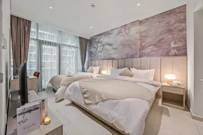 a bedroom with two beds and a tv in it at Infinity Pool & Private Beach 1BR Palm Jumeirah in Dubai