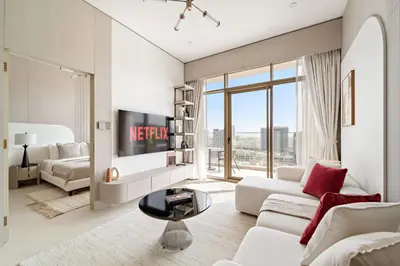 a living room with a couch and a tv at VayK - Bright and Modern One Bedroom in JVC in Dubai