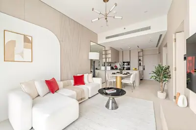 a living room with a white couch and a table at VayK - Bright and Modern One Bedroom in JVC in Dubai