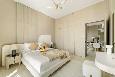 a white bedroom with a bed and a sink at VayK - Contemporary One Bedroom Apartment in JVC in Dubai