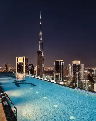 a swimming pool with a city skyline at night at Aurora - 2BR Paramount Hotel Midtown Dubai, Skyline & Burj Khalifa View in Dubai
