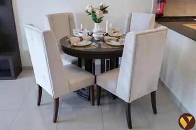 a dining room table with white chairs and a black table with flowers at Vogue Arjan Siraj Tower near Miracle Garden and Dubai Hills Mall, One Bedroom Apartment with Large Balcony and City View, Access to all Amenities in Dubai