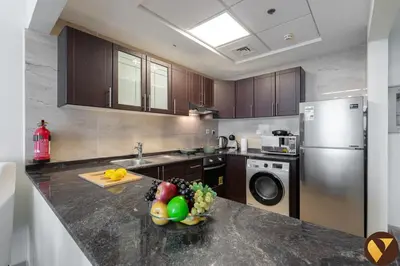 a kitchen with a bowl of fruit on a counter at Vogue Arjan Siraj Tower near Miracle Garden and Dubai Hills Mall, One Bedroom Apartment with Large Balcony and City View, Access to all Amenities in Dubai