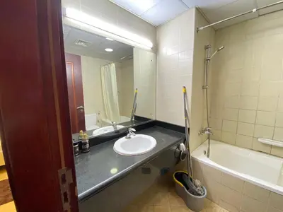 a bathroom with a sink and a tub and a mirror at Studio in discovery garden Near gardens metro station in Dubai