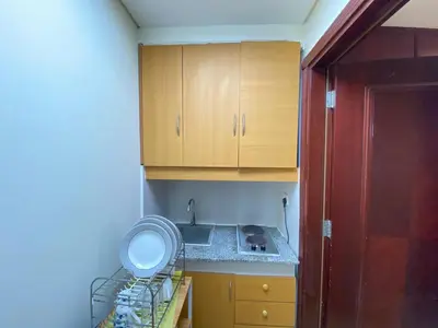 a small kitchen with a sink and wooden cabinets at Studio in discovery garden Near gardens metro station in Dubai
