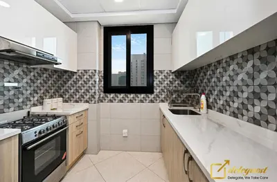 a kitchen with a sink and a stove top oven at Cozy Majan family apartment hosted by Deleguest in Dubai