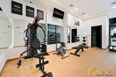 a gym with treadmills ellipticals and exercise bikes at Cozy Majan family apartment hosted by Deleguest in Dubai