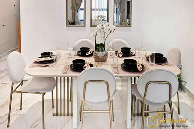 a dining room table with white chairs and a table with glasses at Cozy Majan family apartment hosted by Deleguest in Dubai