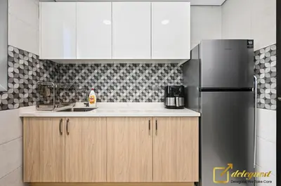 a kitchen with white cabinets and a stainless steel refrigerator at Cozy Majan family apartment hosted by Deleguest in Dubai