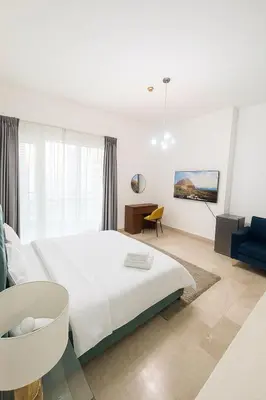 a bedroom with a large white bed and a desk at Cloud 9 Room Marina in Dubai