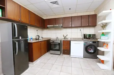 a kitchen with stainless steel appliances and wooden cabinets at Cloud 9 Room Marina in Dubai