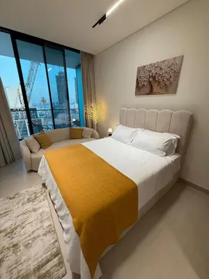 a bedroom with a large bed and a couch at Modern Studio Apartment In JVC in Dubai