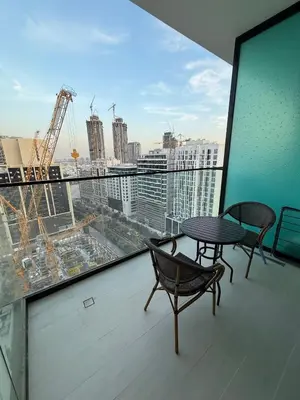 a balcony with a table and chairs and a view of a city at Modern Studio Apartment In JVC in Dubai