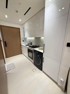a kitchen with a washer and a stove and a door at Modern Studio Apartment In JVC in Dubai