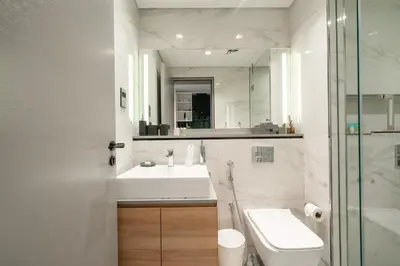 a bathroom with a sink and a toilet and a mirror at Luxury Downtown Studio Pool Marina View in Dubai