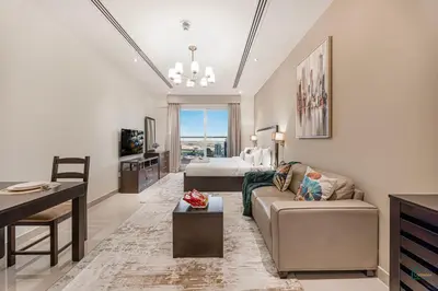 a living room with a couch and a bed and a table at Spacious & cozy Studio in Downtown! in Sabkhah