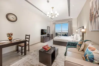 a living room with a couch and a bed and a desk at Spacious & cozy Studio in Downtown! in Sabkhah