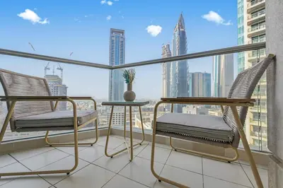a balcony with two chairs and a view of a city at Modern 1 Bed in the Heart of Downtown 5 mins walk from Burj Khalifa and Dubai Mall in Dubai