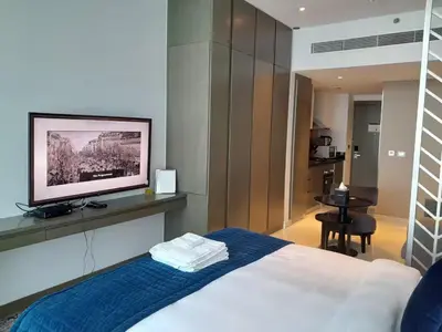 a bedroom with a bed with a flat screen tv at Bright and Modern 1-Bed Studio with Sofa in DAMAC Prive in Dubai