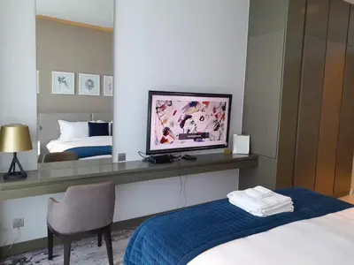 a bedroom with a bed and a desk with a television at Bright and Modern 1-Bed Studio with Sofa in DAMAC Prive in Dubai