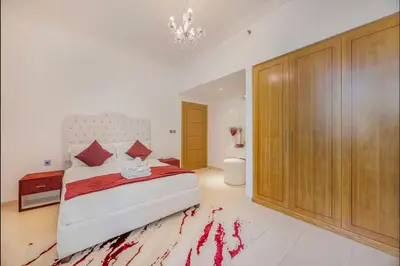 a bedroom with a large bed and a chandelier at FiveX Premium 2BR at Trident Waterfront Marina in Dubai
