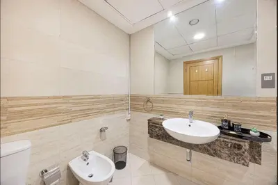 a bathroom with a sink and a toilet and a mirror at FiveX Premium 2BR at Trident Waterfront Marina in Dubai