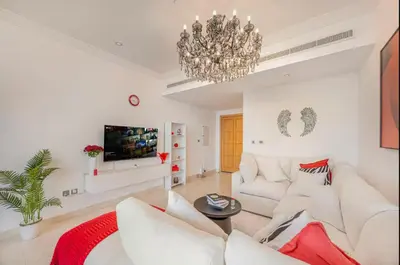 a living room with white furniture and a chandelier at FiveX Premium 2BR at Trident Waterfront Marina in Dubai