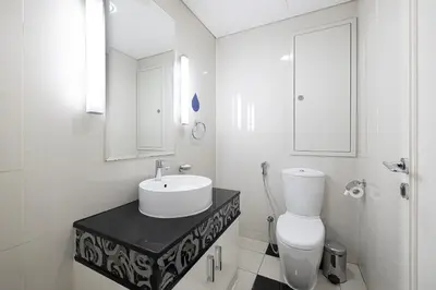 a white bathroom with a sink and a toilet at Damac Maison Mall Street! 2 Bedroom, 2 minute to Dubai Mall! in Dubai