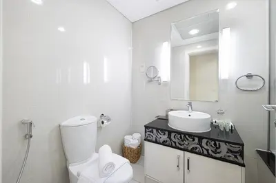 a white bathroom with a toilet and a sink at Damac Maison Mall Street! 2 Bedroom, 2 minute to Dubai Mall! in Dubai