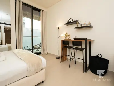 a bedroom with a bed and a desk and a window at Brand New Luxe Studio Sauna, Gym&Pool With Access in Dubai