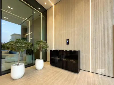 two potted trees in a room with a fireplace at Brand New Luxe Studio Sauna, Gym&Pool With Access in Dubai