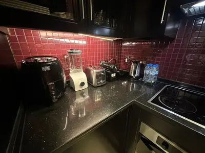 a kitchen counter with a blender and pink tiles at Dubai Mall Luxury 1Bed The Address in Dubai