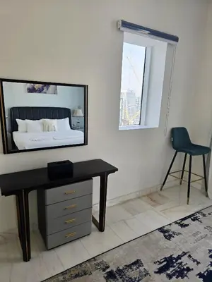a bedroom with a desk and a mirror on the wall at Bayz by Danube by That Place Home Living in Dubai