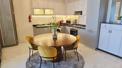 a kitchen with a wooden table and chairs in a kitchen at Bayz by Danube by That Place Home Living in Dubai