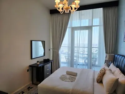 a bedroom with a bed and a mirror and a window at Bayz by Danube by That Place Home Living in Dubai