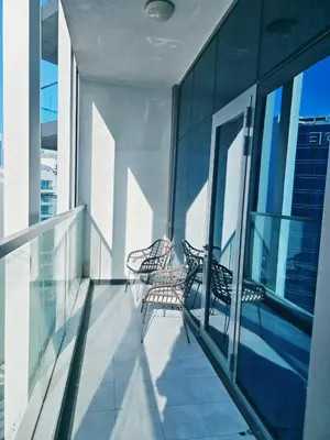 two chairs sitting on the balcony of a building at Bayz by Danube by That Place Home Living in Dubai