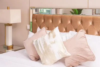 a bed with white pillows and a brown headboard at Elite Royal Apartment - Full Burj Khalifa & New Fountain View - Panoramic - Luxurious - Magnus in Dubai